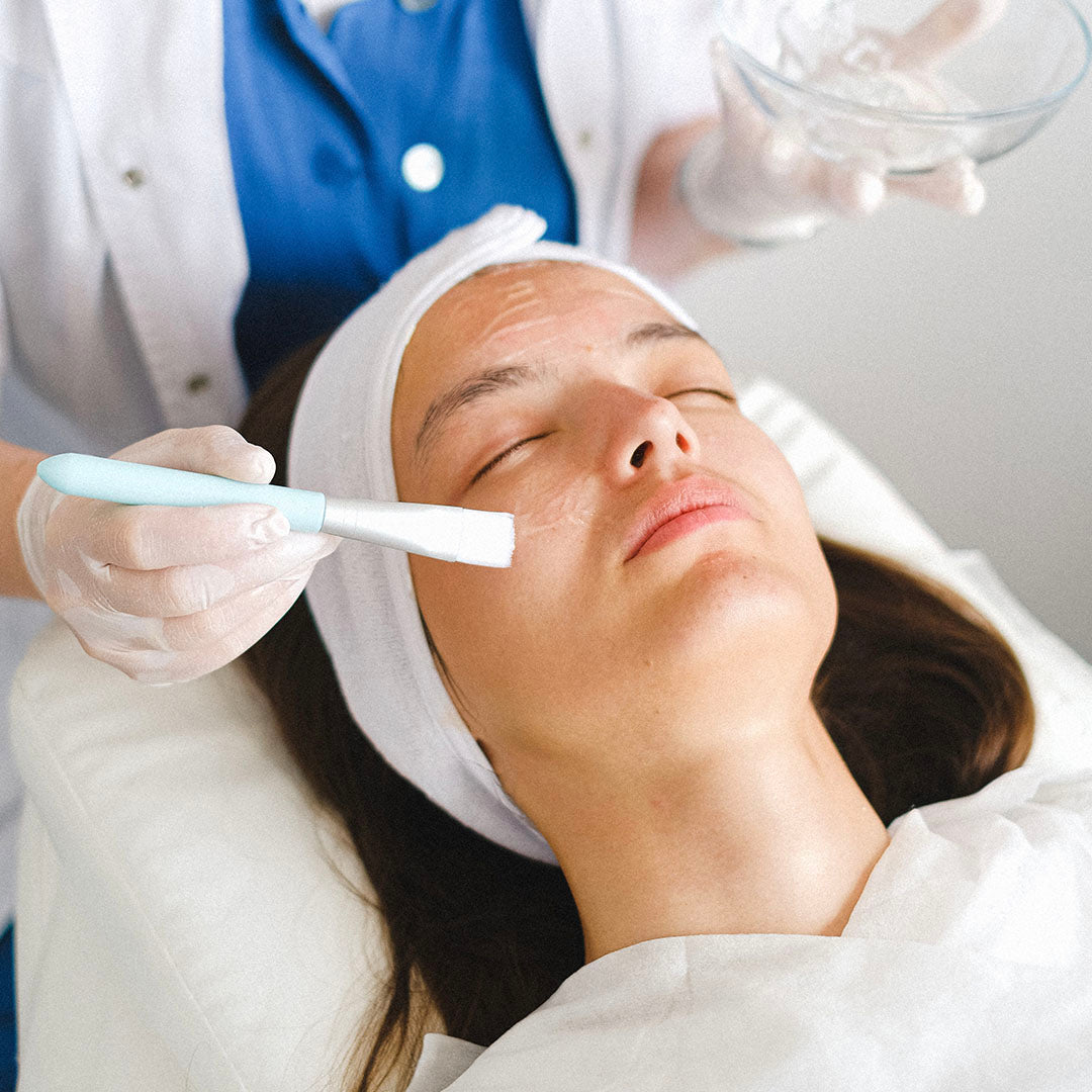 a photo of a patient receiving a chemical peel treatment to her face