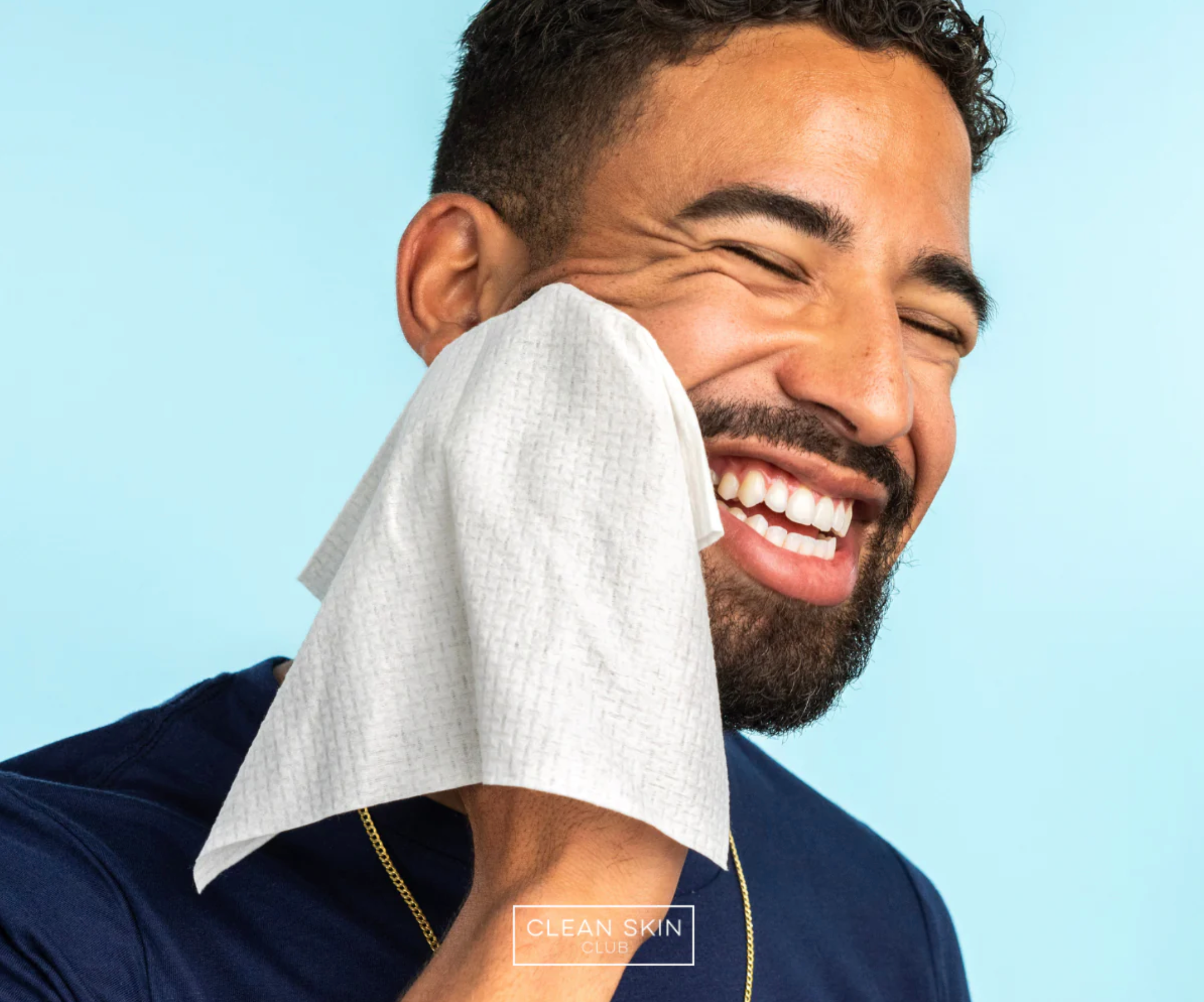 a man using a clean skin club towel on his face